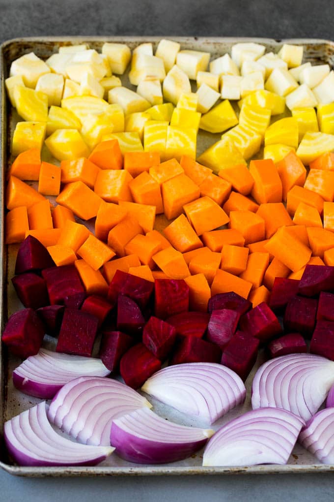 Roasted Root Vegetables Recipe | Roasted Sweet Potatoes | Roasted Beets | Roasted Carrots #carrots #beets #vegetables #sweetpotatoes #fall #parsnips #sidedish #sraye #cleaneating #healthy Onions, carrots, beets, parsnips and sweet potatoes on a sheet pan.