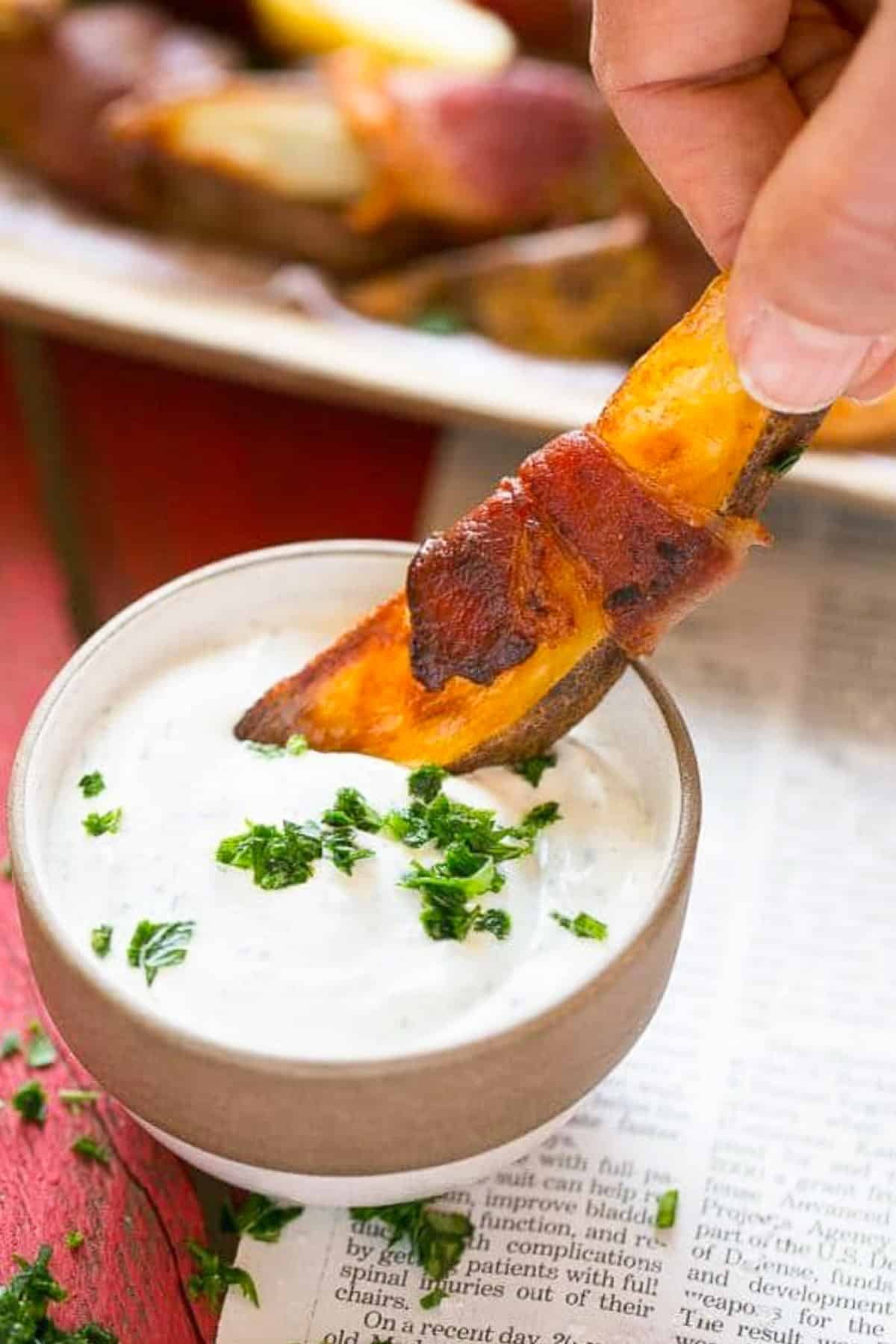 Bacon Wrapped Potato Wedges Recipe | Best Potato Wedges | Bacon Wrapped French Fries | Bacon Potato Wedges #bacon #potato #fries #dinner #sraye A hand putting bacon wrapped potatoes into ranch dip.