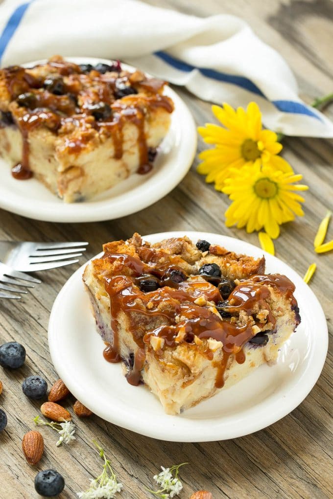 Blueberry Bread Pudding Recipe | Blueberry Bread Pudding | Easy Bread Pudding #blueberry #breadpudding #dessert #sraye Two pieces of blueberry bread pudding on plates with salted caramel on top.