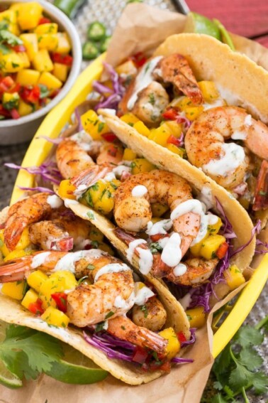 Shrimp tacos with sweet and tangy mango salsa and creamy cilantro lime sauce.