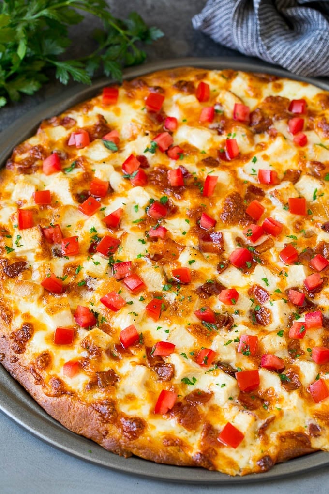 Chicken Alfredo Pizza Recipe #pizza #chicken #bacon #dinner #sraye A pizza topped with chicken, bacon, tomatoes and parsley.