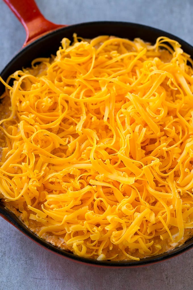 Buffalo Ranch Chicken Dip | Buffalo Chicken Dip | Baked Buffalo Dip | Cheesy Buffalo Dip #buffalowings #buffalochicken #dip #lowcarb #appetizer #sraye Buffalo chicken dip topped with shredded cheddar cheese, ready to go into the oven.