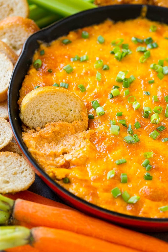 Buffalo Ranch Chicken Dip | Buffalo Chicken Dip | Baked Buffalo Dip | Cheesy Buffalo Dip #buffalowings #buffalochicken #dip #lowcarb #appetizer #sraye Buffalo ranch chicken dip with a baguette slice in it.