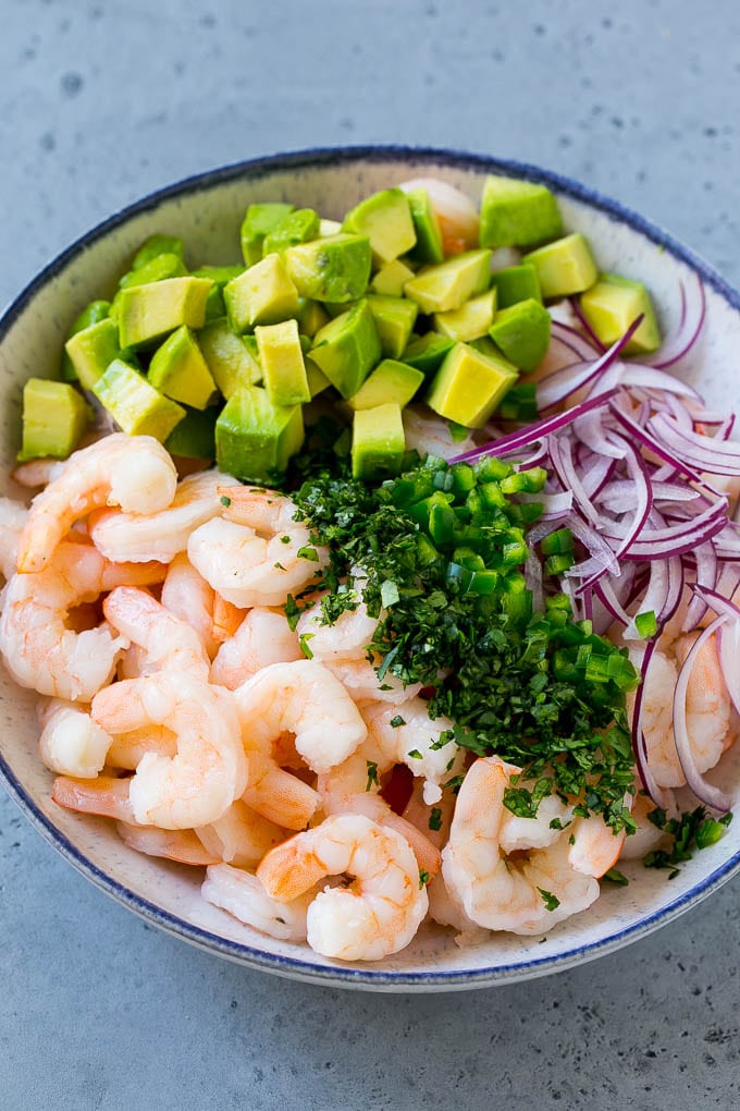 Mexican Shrimp Cocktail Recipe | Coctel de Camarones | Shrimp Cocktail | Mexican Shrimp #shrimp #appetizer #avocado #mexican #sraye Shrimp, red onion, avocado, jalapeno and cilantro in a serving bowl.