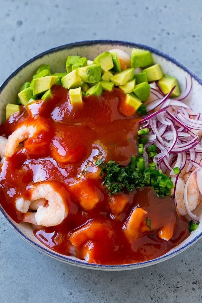Mexican Shrimp Cocktail Recipe | Coctel de Camarones | Shrimp Cocktail | Mexican Shrimp #shrimp #appetizer #avocado #mexican #sraye Shrimp, avocado, red onion and cilantro topped with cocktail sauce.