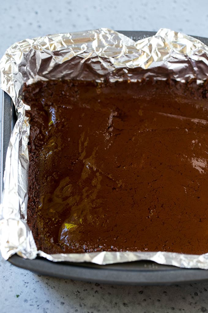 Chocolate Peanut Butter Fudge Recipe | Peanut Butter Cup Fudge | Easy Fudge Recipe #chocolate #peanutbutter #fudge #baking #dessert #sraye A layer of chocolate fudge in a pan.