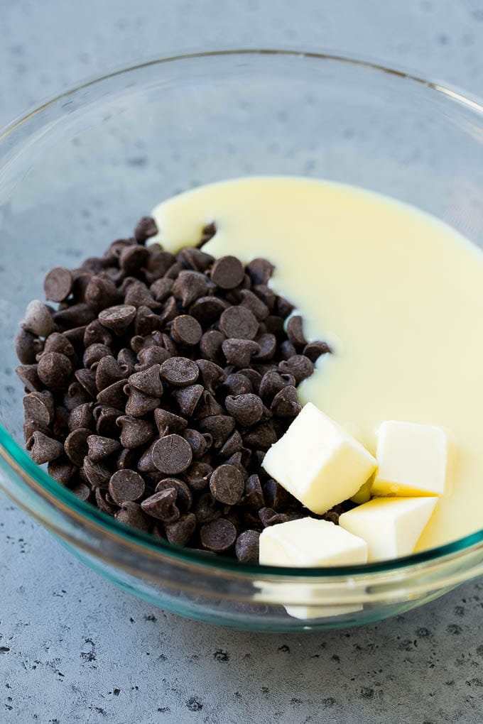 Chocolate Peanut Butter Fudge Recipe | Peanut Butter Cup Fudge | Easy Fudge Recipe #chocolate #peanutbutter #fudge #baking #dessert #sraye Chocolate chips, condensed milk and butter in a mixing bowl.