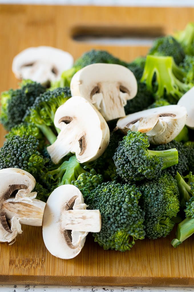 Chicken and Broccoli Stir Fry Recipe | Chicken Stir Fry | Healthy Chicken Recipe | Chicken and Broccoli | Chinese Food #chicken #broccoli #stirfry #healthy #cleaneating #dinner #sraye Broccoli florets and sliced mushrooms on a cutting board.