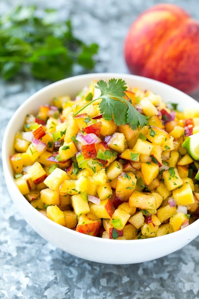 Peach Salsa | Fruit Salsa #peaches #salsa #dip #appetizer #sraye Peach salsa in a bowl made with red onion, jalapeno and cilantro.