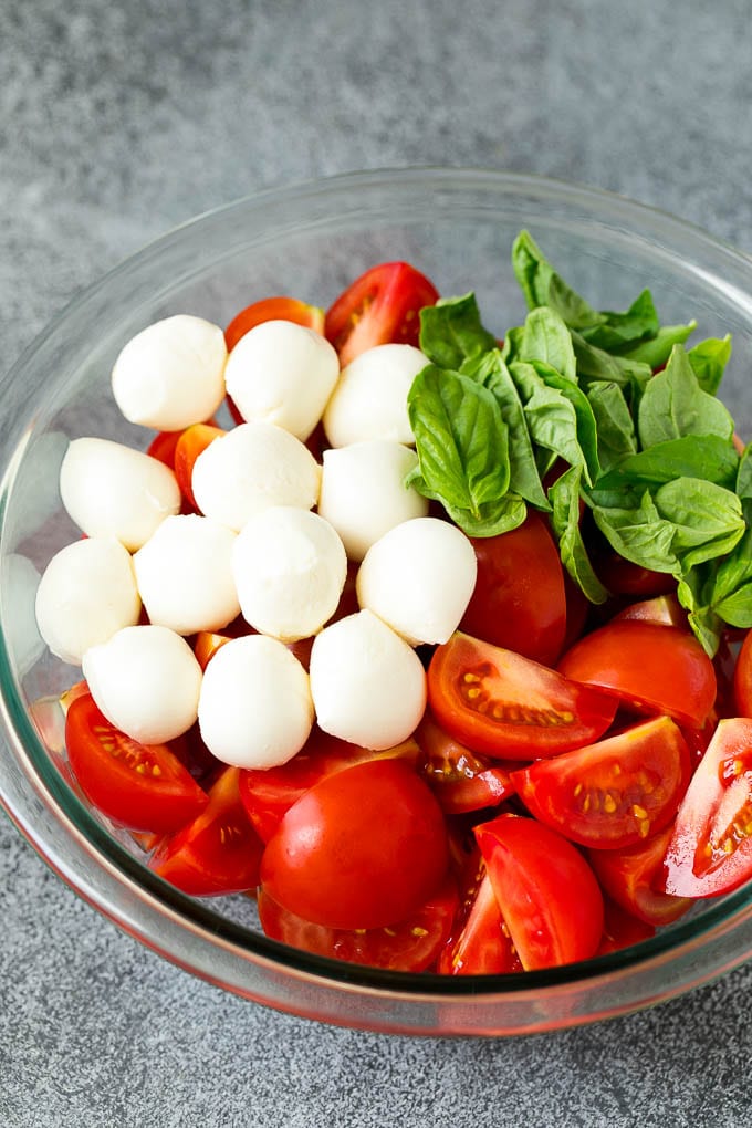 Caprese Salad Recipe | Tomato Salad #salad #tomato #mozzarella #cheese #basil #caprese #summer #sraye Tomatoes, mozzarella and basil in a bowl.