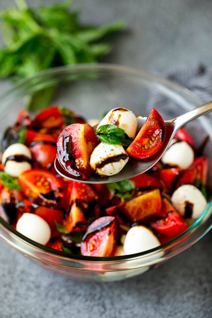 Caprese Salad Recipe | Tomato Salad #salad #tomato #mozzarella #cheese #basil #caprese #summer #sraye A serving spoon of caprese salad with tomato, mozzarella and basil.