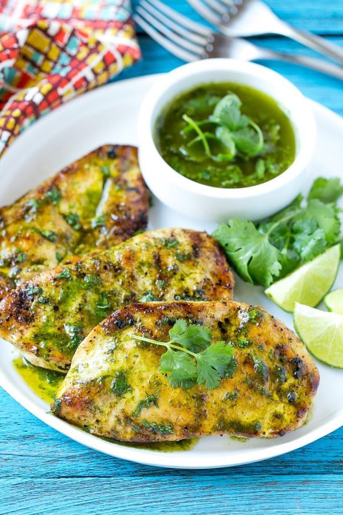 Cilantro Lime Chicken | Grilled Chicken #chicken #grilling #cilantro #lime #dinner #sraye Cilantro lime chicken topped with sauce and served with lime wedges.