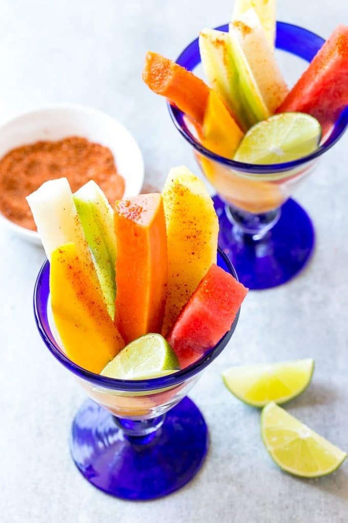 Mexican Fruit Cups | Fruit Cups | Mexican Fruit | Tropical Fruit #fruit #fruitcup #watermelon #pineapple #snack #healthy #sraye Spears of watermelon, cucumber, jicama, mango and pineapple in glasses.
