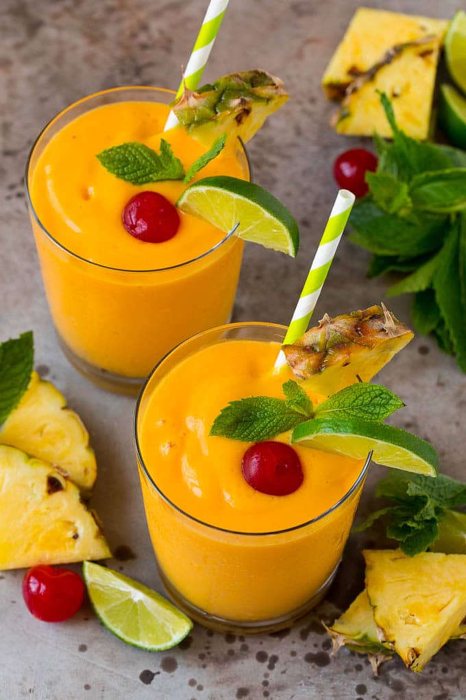 Tropical Smoothie Recipe | Mango Smoothie | Pineapple Smoothie #smoothie #mango #pineapple #banana #drink #sraye Tropical smoothie garnished with mint, limes and pineapple.