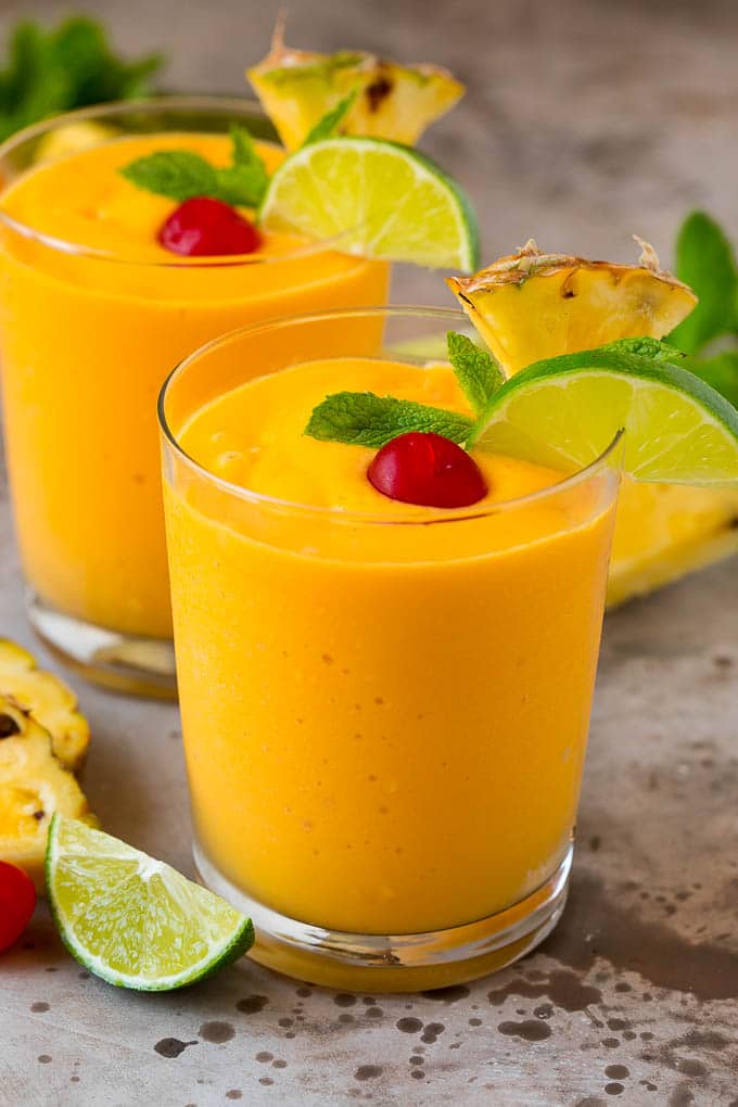 Tropical Smoothie Recipe | Mango Smoothie | Pineapple Smoothie #smoothie #mango #pineapple #banana #drink #sraye Two tropical smoothies with fresh mint, lime wedges and sliced pineapple.