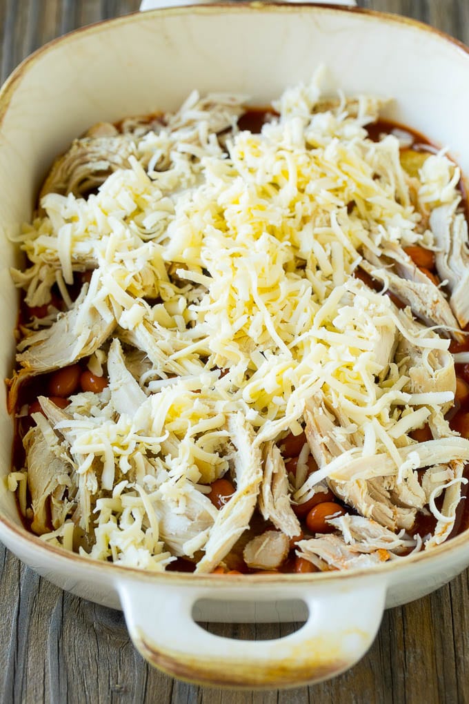 Chicken Enchilada Casserole Recipe | Chicken Enchiladas | Easy Casserole Recipe | Enchilada Casserole #chicken #casserole #enchiladas #cheese #beans #dinner #sraye Chicken, beans and shredded cheeses in a casserole dish.