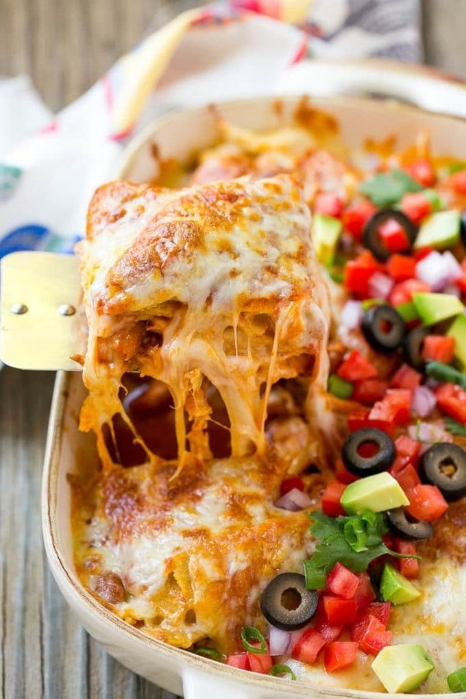 Chicken Enchilada Casserole Recipe | Chicken Enchiladas | Easy Casserole Recipe | Enchilada Casserole #chicken #casserole #enchiladas #cheese #beans #dinner #sraye A spatula serving up a portion of cheesy chicken enchilada casserole.