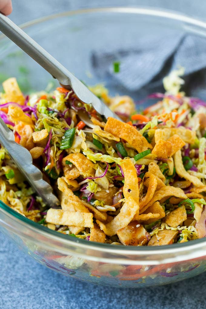 Chinese Chicken Salad Recipe | Asian Chicken Salad #salad #chicken #chickensalad #cabbage #lunch #dinner #sraye Tongs serving up a portion of Asian chicken salad.