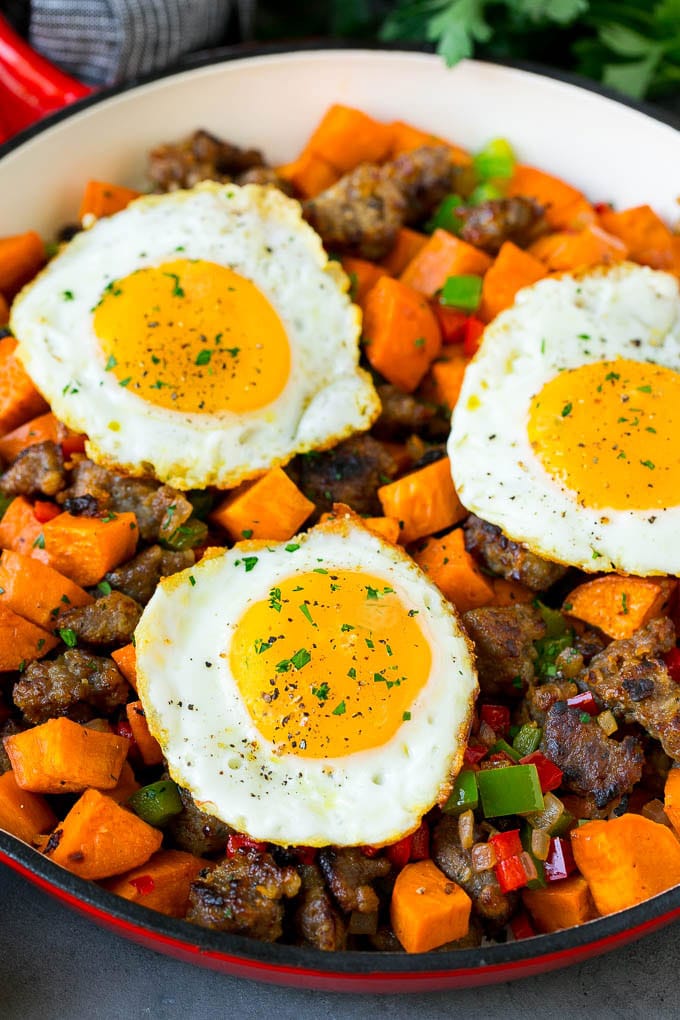 Sweet Potato Hash #sweetpotato #sausage #breakfast #brunch #sraye A pan of sweet potato hash topped with fried eggs.