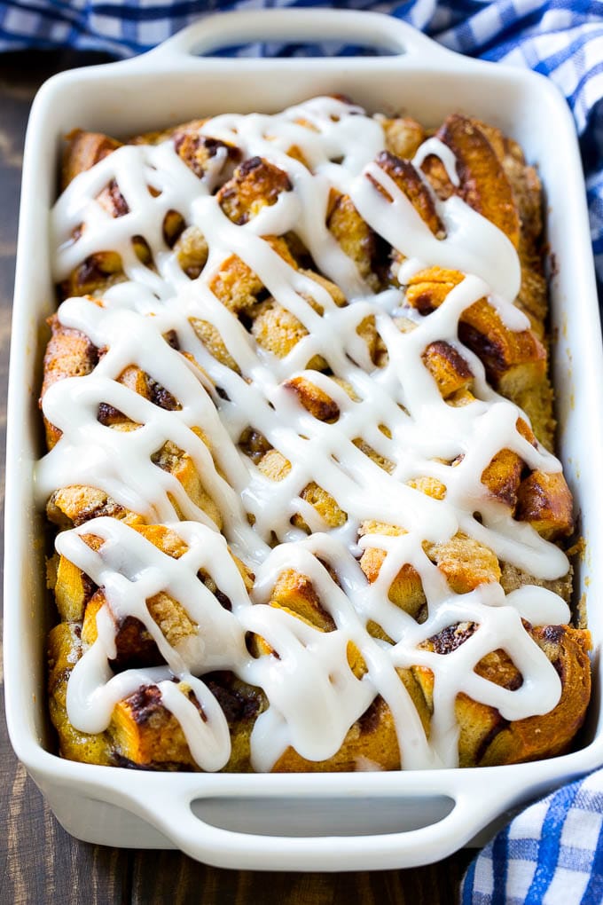 Cinnamon Roll French Toast Casserole | Cinnamon Roll French Toast Bake | Cinnamon Roll French Toast | Cinnamon French Toast #casserole #frenchtoast #cinnamonrolls #breakfast #sraye A casserole dish of cinnamon roll french toast with icing poured over the top.