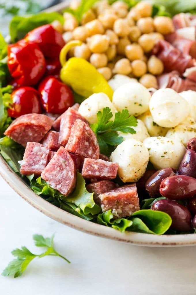 Antipasto Salad Recipe | Italian Salad | Main Course Salad | Antipasto Recipe #salad #salami #italianfood #dinner #lunch #sraye A bed of greens topped with antipasto salad including meats, cheeses, beans and vegetables.