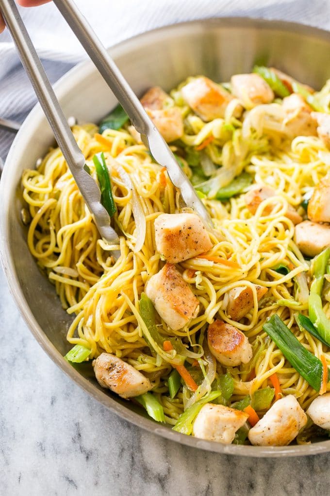 Chicken Chow Mein Recipe | Easy Chicken Recipe | Chow Mein | Chinese Food #chowmein #takeout #asianfood #sraye A pan of chicken chow mein with tongs pulling out a serving.