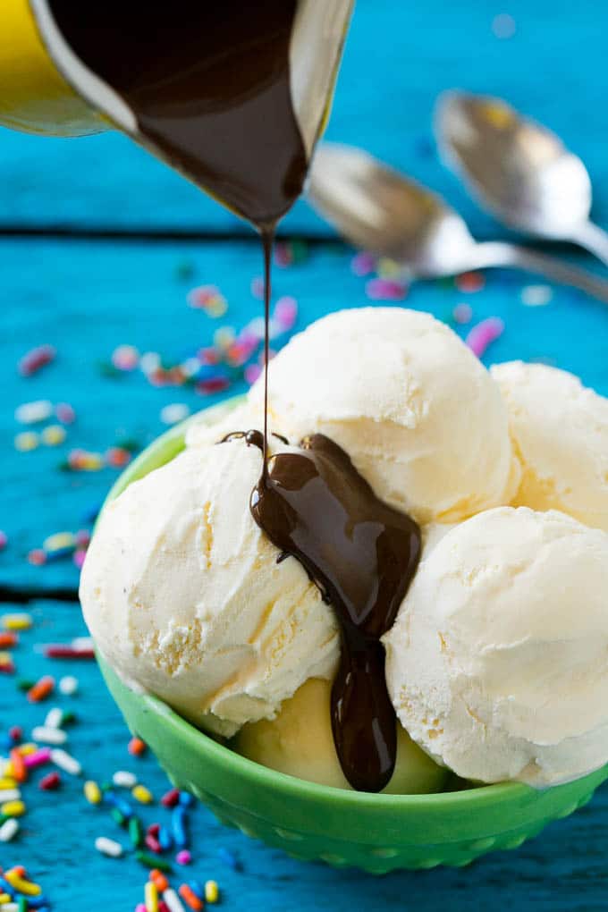 Homemade Magic Shell Recipe | Chocolate Ice Cream Topping | Chocolate Sauce | Hard Chocolate Coating #chocolate #icecream #dessert #sraye A pitcher of chocolate sauce being poured over vanilla ice cream.