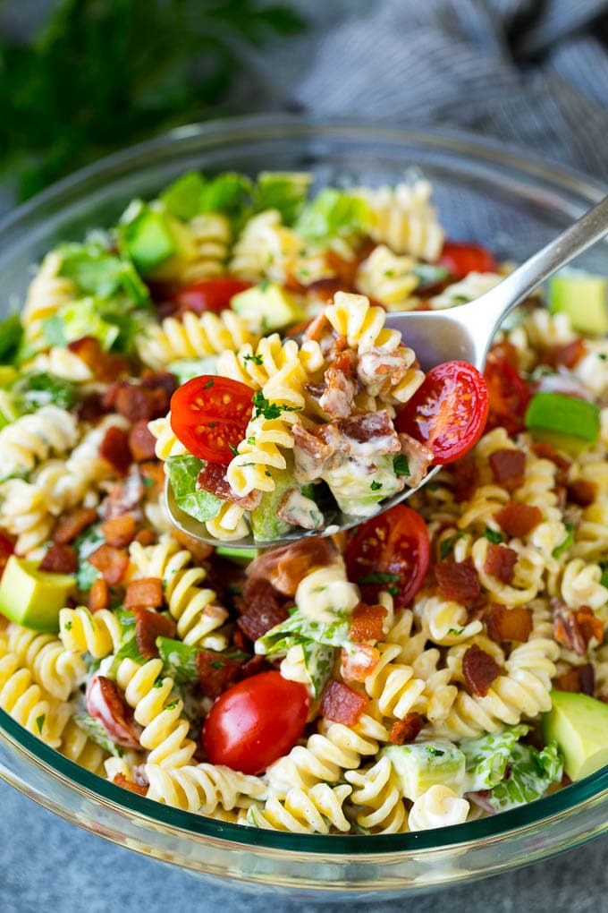 BLT Pasta Salad Recipe | Easy Pasta Salad | Bacon Pasta Salad #salad #pasta #blt #bacon #avocado #dinner #sraye A serving spoon filled with BLT pasta salad.