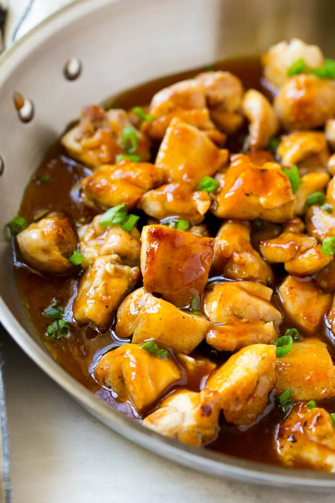 Bourbon Chicken | Sauteed Chicken | Chicken Stir Fry | Easy Chicken Recipe #chicken #dinner #sraye Bourbon chicken in a skillet coated in sauce and topped with green onions.