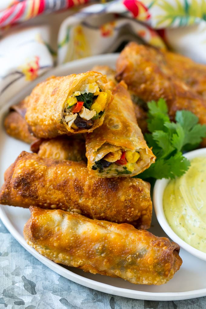 Southwestern Egg Rolls Recipe | Easy Egg Roll Recipe | Mexican Appetizer | Egg Roll Recipe | Southwest Egg Rolls #eggrolls #appetizer #chicken #snack #sraye Morsels stuffed with diced chicken, bell peppers, black beans and cheese on a serving plate.
