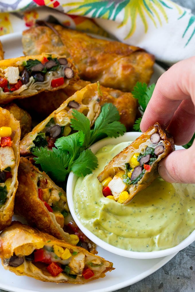 Southwestern Egg Rolls Recipe | Easy Egg Roll Recipe | Mexican Appetizer | Egg Roll Recipe | Southwest Egg Rolls #eggrolls #appetizer #chicken #snack #sraye A southwestern egg roll being dipped into avocado sauce.