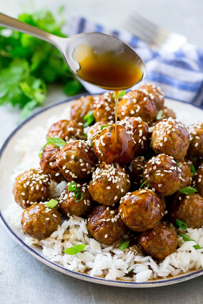 Teriyaki Meatballs Recipe | Asian Meatballs Recipe | Easy Meatball Recipe | Appetizer Meatballs #meatballs #teriyaki #beef #rice #dinner #sraye Teriyaki sauce spooned over a pile of meatballs on a bed of rice.
