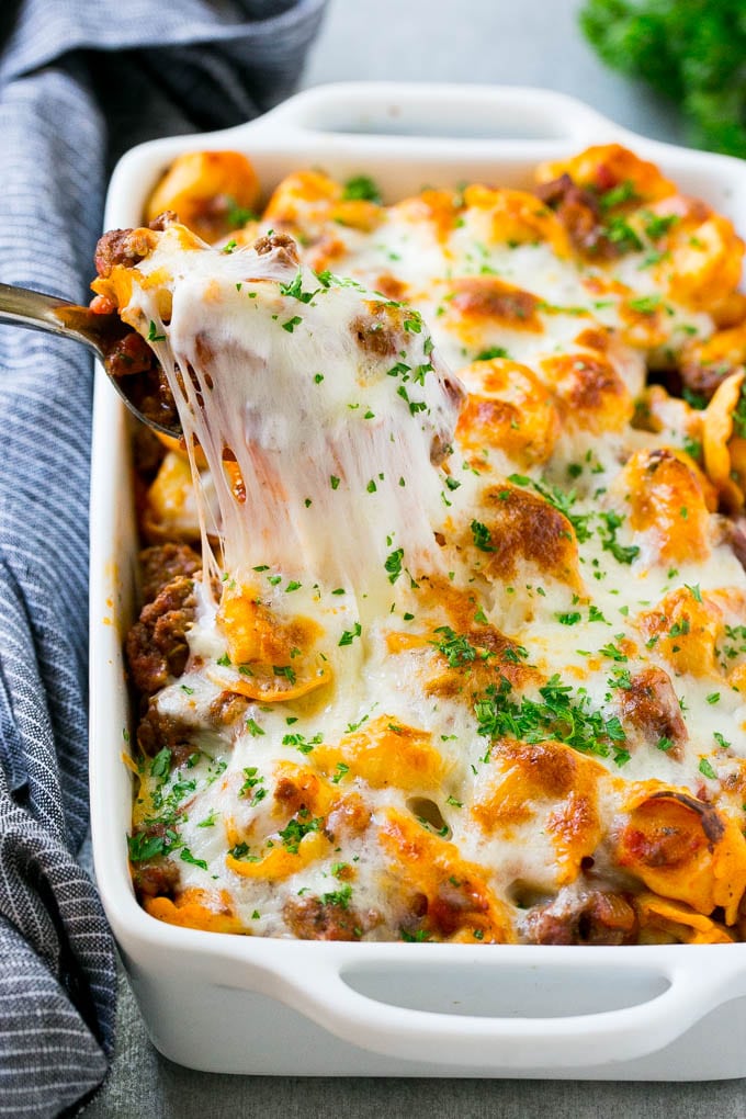 Baked Tortellini with Meat Sauce Recipe | Cheese Tortellini | Tortellini Recipe | Baked Pasta Recipe #tortellini #bakedtortellini #meatsauce #pasta #dinner #sraye A pan of cheesy baked tortellini with a spoon lifting up a portion.