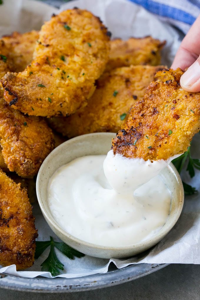 Baked Fried Chicken Recipe | Oven Fried Chicken | Baked Chicken Fingers | Crispy Chicken Fingers #chicken #friedchicken #bakedchicken #ovenfriedchicken #chickenfingers #dinner #sraye A chicken finger being dipped into ranch dressing.