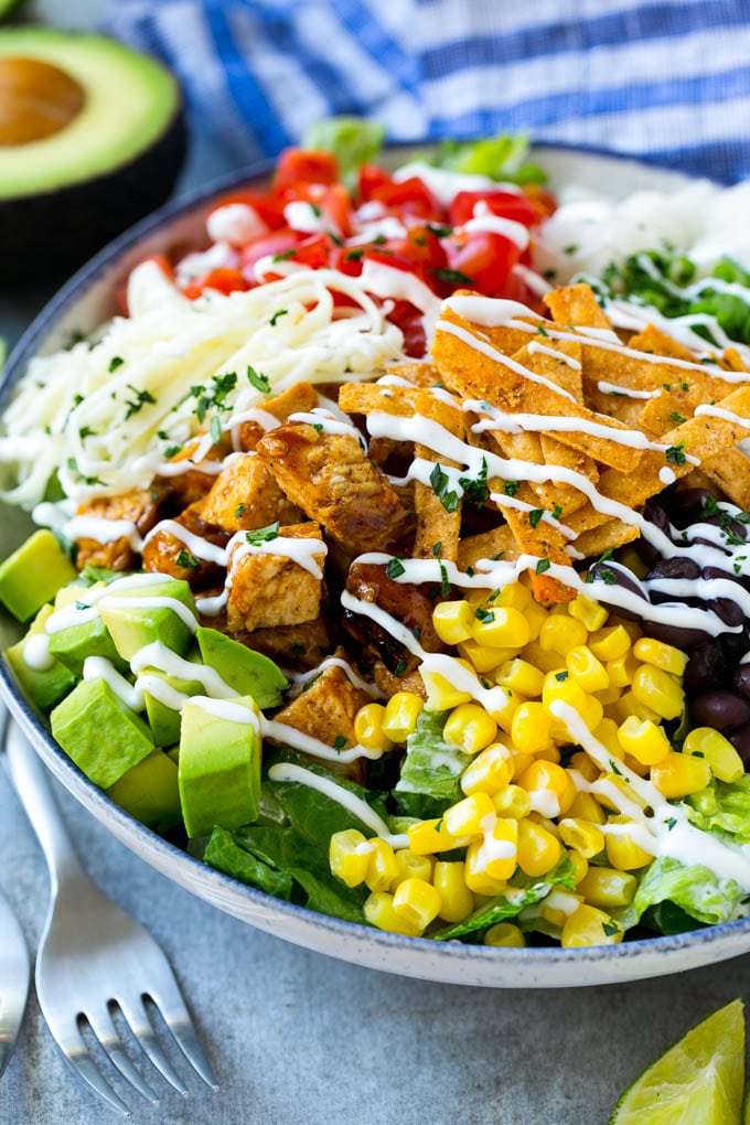 BBQ Chicken Salad Recipe | Chopped BBQ Chicken Salad | CPK Copycat Recipe | California Pizza Kitchen Copycat Recipe | Chicken Ranch Salad #copycat #CPK #BBQchicken #chicken #salad #dinner #sraye A bowl of BBQ chicken salad topped with a drizzle of ranch dressing.