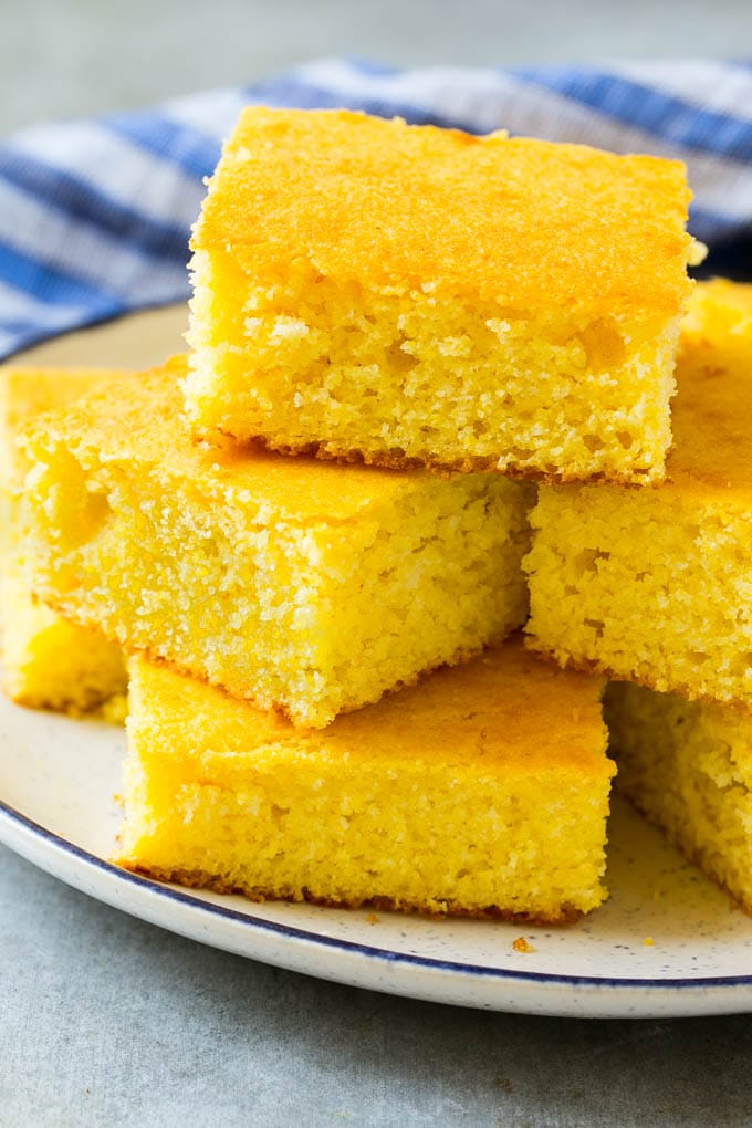 Honey Cornbread Recipe | Buttermilk Cornbread | Easy Cornbread | Homemade Cornbread | Cast Iron Cornbread #cornbread #honey #buttermilk #bread #sraye A plate full of squares of bread made with cornmeal.