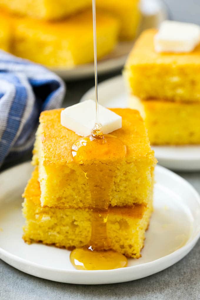 Honey Cornbread Recipe | Buttermilk Cornbread | Easy Cornbread | Homemade Cornbread | Cast Iron Cornbread #cornbread #honey #buttermilk #bread #sraye A stack of cornbread topped with butter and honey
