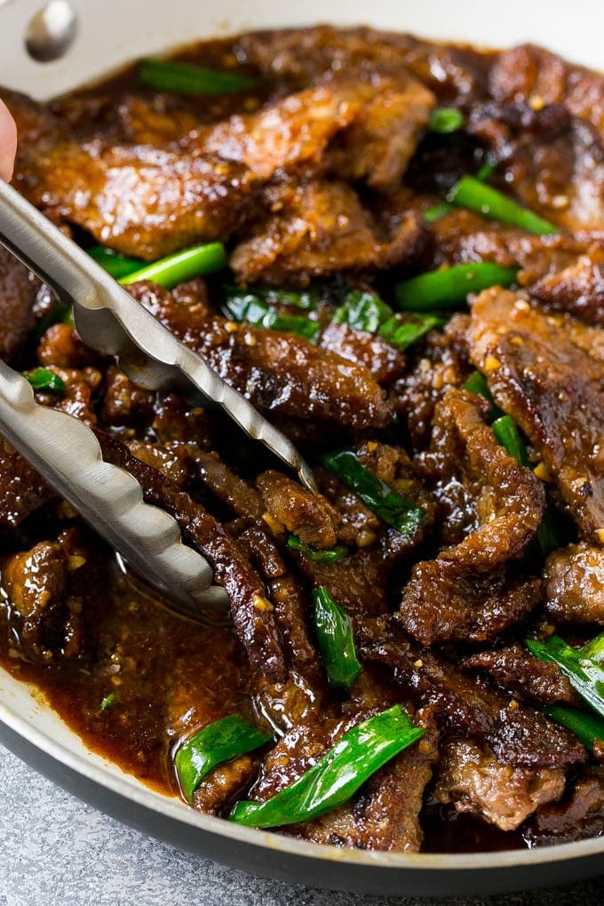 Mongolian Beef Recipe | Asian Beef Recipe | Chinese Beef | Beef Stir Fry #Chinese #Mongolian #Asian #mongolianbeef #beef #sraye #dinner A pan of Mongolian beef with tongs in it.