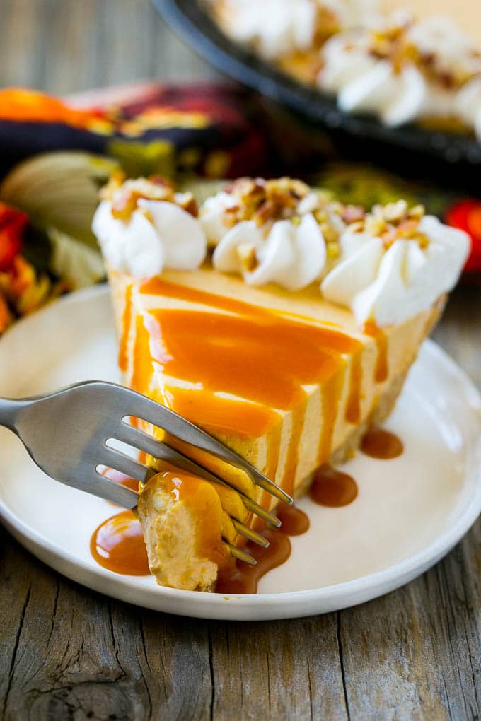 No Bake Pumpkin Cheesecake Recipe | Pumpkin Cheesecake | No Bake Cheesecake | Thanksgiving Dessert | Pumpkin Dessert #nobake #cheesecake #pumpkin #pumpkinpie #pumpkincheesecake #nobakecheesecake #dessert #sraye A fork cutting into a slice of no bake pumpkin cheesecake.