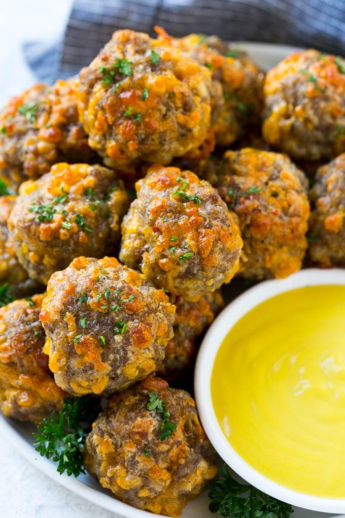 Sausage Cheese Balls Recipe | Sausage Balls Recipe | Bisquick Sausage Balls #sausage #sausageballs #balls #appetizer #cheeseballs #sraye A platter of sausage cheese balls with honey mustard sauce for dipping.