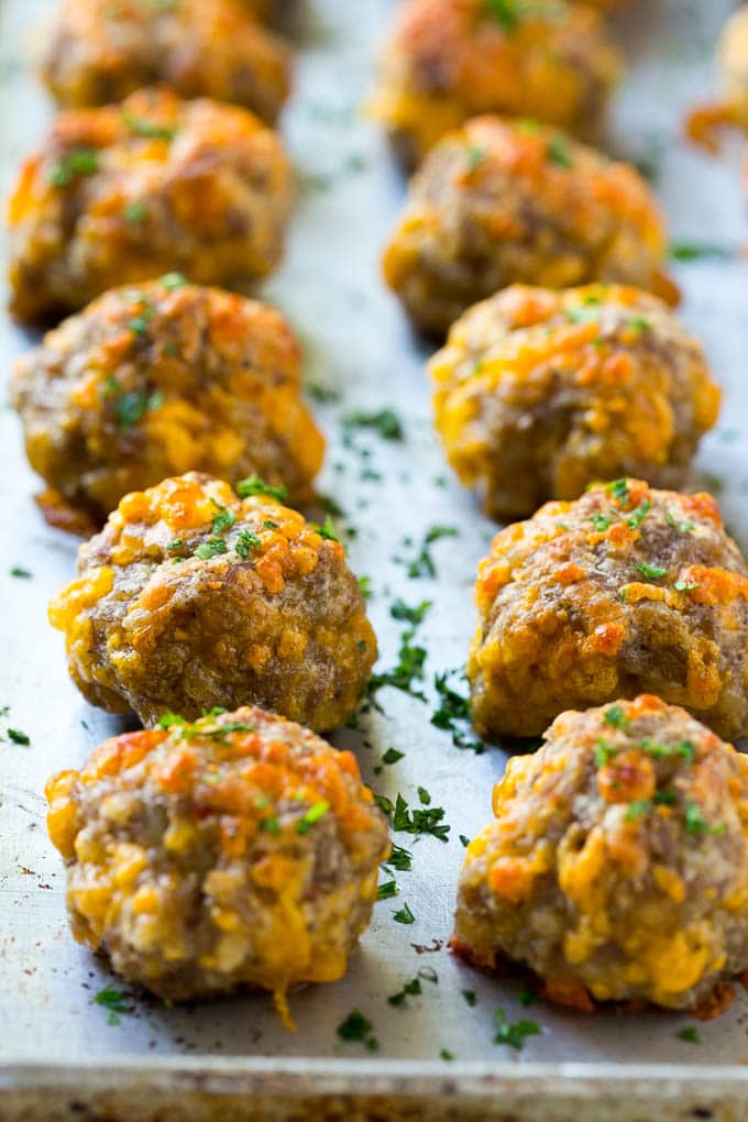 Sausage Cheese Balls Recipe | Sausage Balls Recipe | Bisquick Sausage Balls #sausage #sausageballs #balls #appetizer #cheeseballs #sraye Cooked meatballs on a baking sheet.