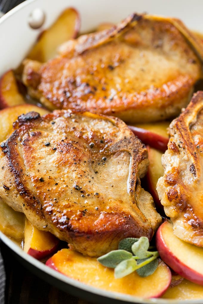 Apple Pork Chops Recipe | Pork Chops with Apples | Cider Pork Chops | Bone In Pork Chops Recipe #pork #porkchops #fall #apple #dinner #sraye Seared pork in a pan in a sweet and savory sauce with fresh herbs.