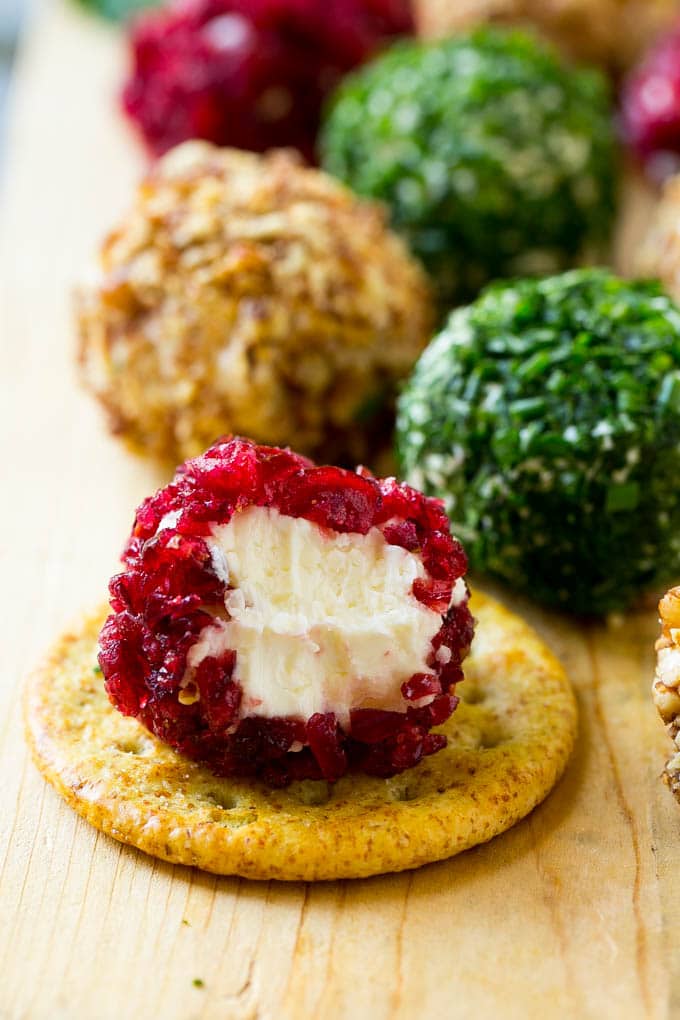 Cheese Ball Bites Recipe | Holiday Cheese Ball Recipe | Pecan Cheese Ball | Cranberry Cheese Ball | Mini Cheese Balls #cheeseball #cheese #appetizer #sraye A cranberry crusted ball of cheese on a cracker.