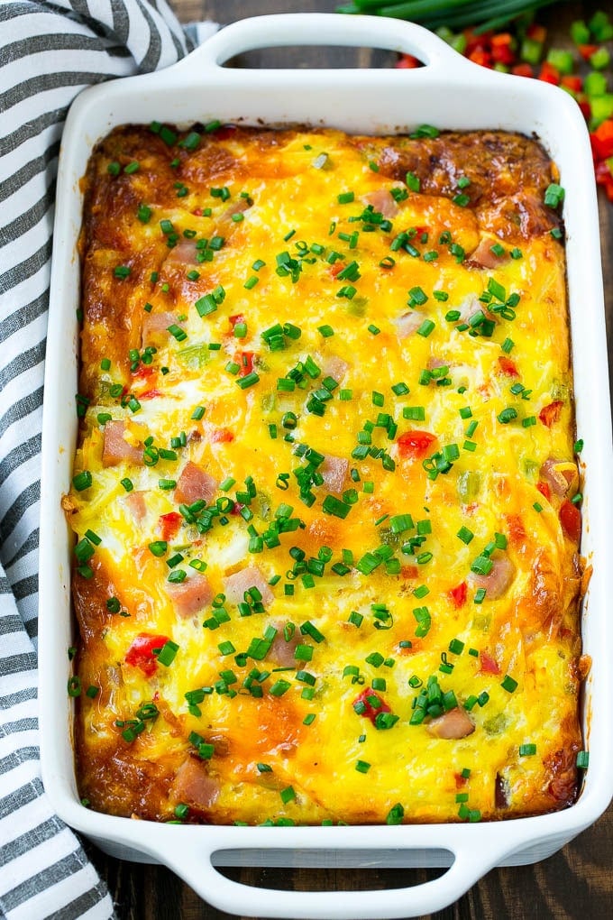 Hash Brown Egg Casserole Recipe | Breakfast Casserole with Ham | Hash Brown Casserole | Ham and Egg Casserole | Egg Casserole with Ham #casserole #breakfast #eggs #egg #hashbrown #sraye Hash brown egg casserole in a white baking dish.