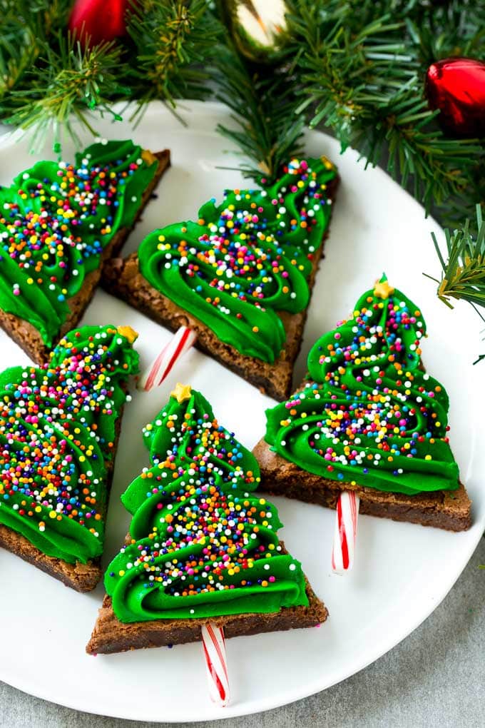 title="Christmas Tree Brownies | Christmas Brownies | Holiday Brownies | Christmas Tree Dessert #brownies #dessert #christmas #holiday #dessert #sraye" Christmas Brownies topped with frosting and rainbow sprinkles on a plate.