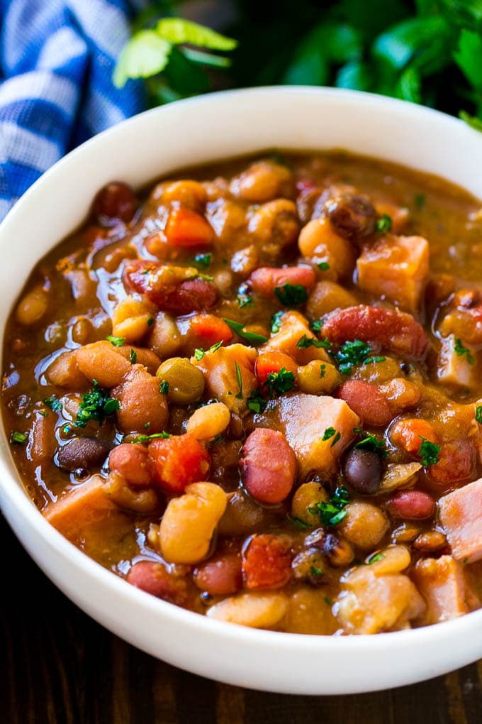 Slow Cooker Ham Bone Soup | Ham and Bean Soup | Ham Bone and Bean Soup | Ham Soup | Leftover Ham Recipe #ham #hamsoup #leftoverham #soup #slowcooker #crockpot #sraye A bowl of ham bone soup with beans and vegetables.