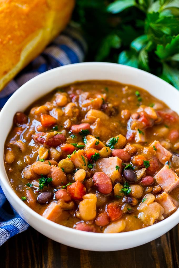 Slow Cooker Ham Bone Soup | Ham and Bean Soup | Ham Bone and Bean Soup | Ham Soup | Leftover Ham Recipe #ham #hamsoup #leftoverham #soup #slowcooker #crockpot #sraye Crock pot ham bone soup in a bowl topped with parsley.