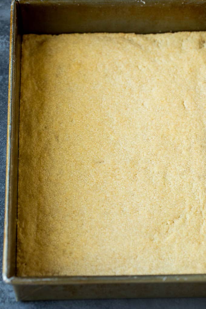 Pecan Pie Bars Recipe #pecans #pie #fall #pecanpie #dessert #thanksgiving #sraye A shortbread crust in a baking pan.