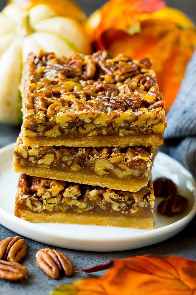 Pecan Pie Bars Recipe #pecans #pie #fall #pecanpie #dessert #thanksgiving #sraye A stack of pecan pie bars on a plate.