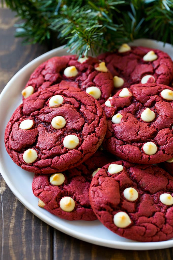 Red Velvet Cookies Recipe | Red Velvet Cookies with White Chocolate Chips | Red Velvet Cake Mix Cookies #redvelvet #cookies #whitechocolate #christmas #sraye Red Velvet Cookies on a serving plate with holiday decorations nearby,
